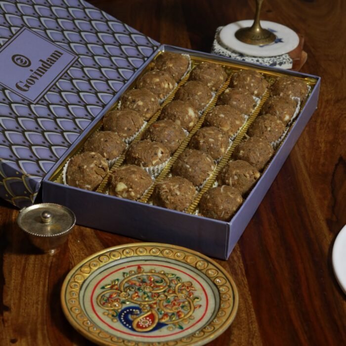 Balwan laddu served with glass of milk on rustic wooden table