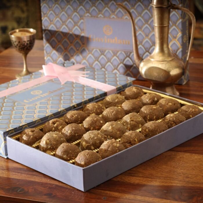 Assorted sizes of Balwan laddu arranged in a pyramid on decorative silver platter