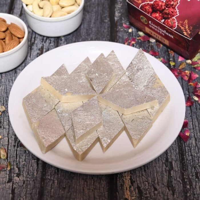 Cross-section of Kaju Katli showing fine, grain-like texture with a gleaming silver top layer