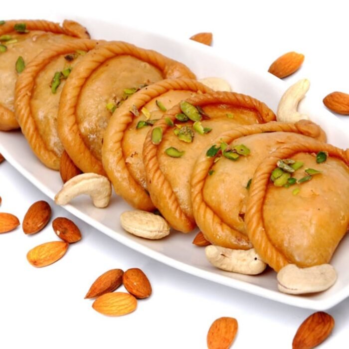 Cross-section of gujiya revealing rich khoya and nut filling with visible cardamom specks