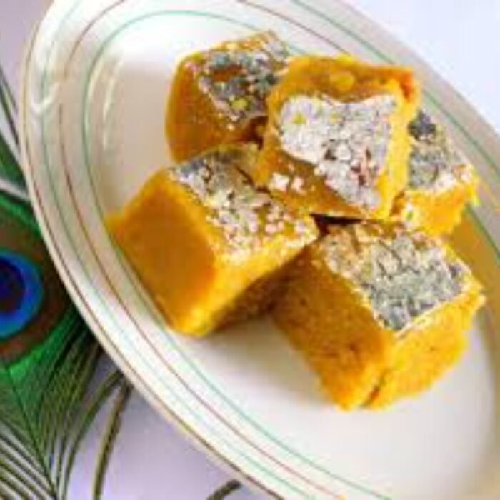 Cross-section of mewa mango barfi revealing dense texture with visible nut pieces and mango fibers