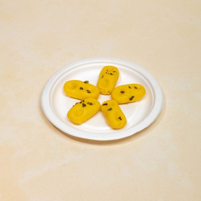 Close-up of kesar peda texture showing fine milk solid grains with visible saffron specks