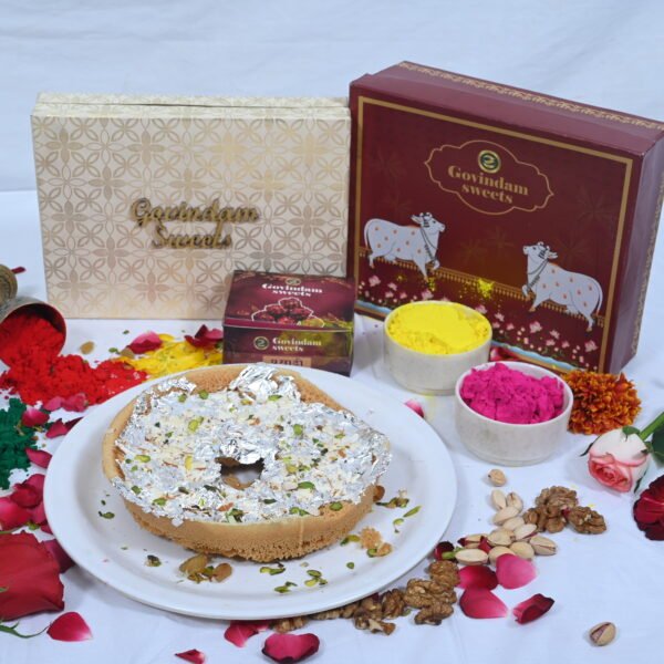 Meetha Ghewar garnished with silver leaf and rose petals.